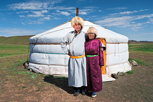 Mongolian couple in national clothing, ger (yurt) in the background.http://bhphoto.pl/IS/mongolia_380.jpg