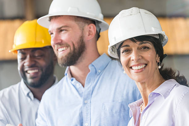 Hispanic woman with group of workers in hardhats