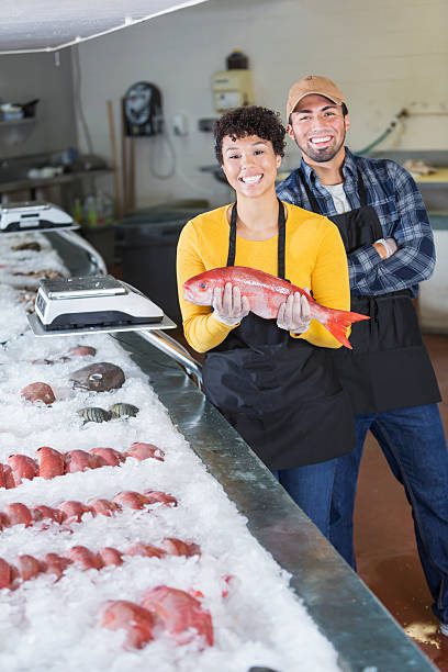 istock Young mixed race couple working in fish market 637288884