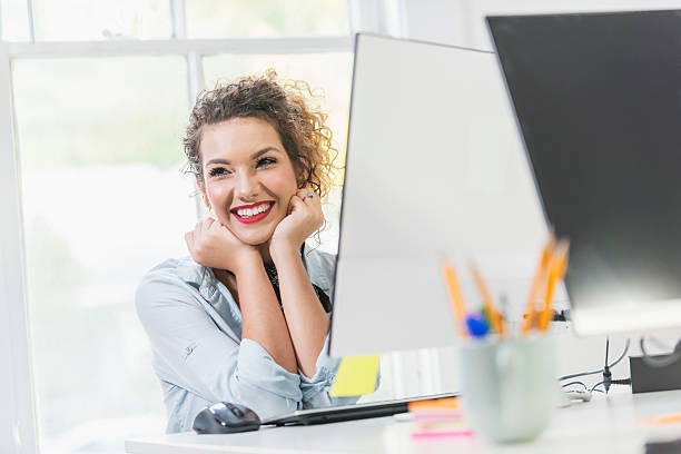 istock Happy young woman sitting at desktop computer 637289116