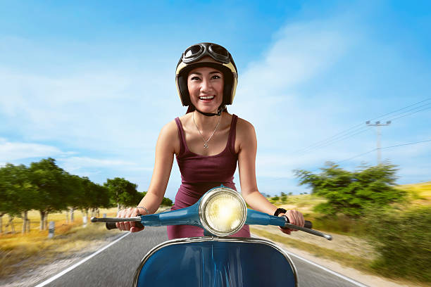 istock Attractive asian woman riding a blue scooter 637291846