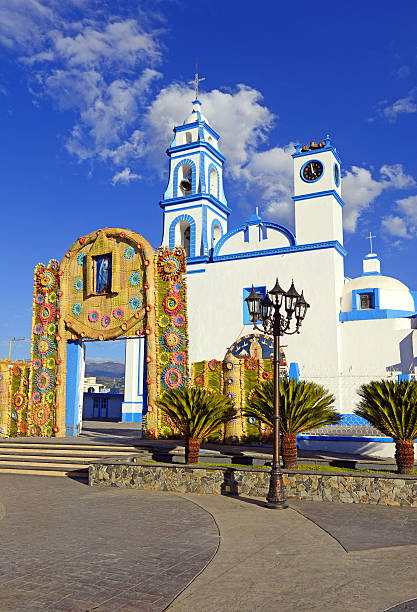 Vibrant floral cross, crafted with colorful roses, decorates a church in Quito, Ecuador, during the Holy Week celebrations, symbolizing faith and tradition