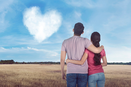 Young asian couple looking cloud with heart shape in the sky
