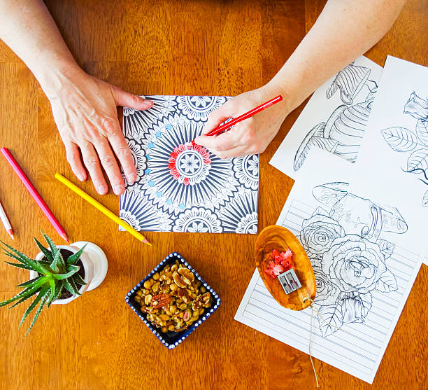 istock Woman's Hands Holding Red Pencil Crayon in Left Hand Coloring 637294524