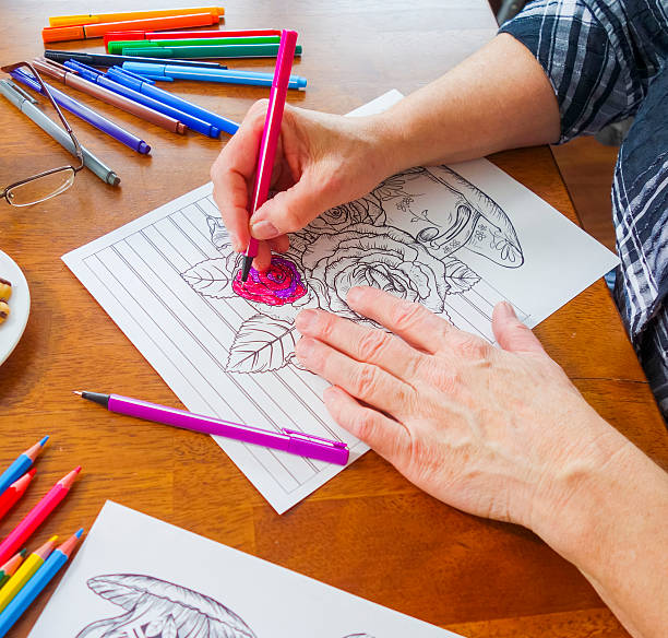 istock Woman's Coloring Flowers with Pink Marker Right Hand 637295638