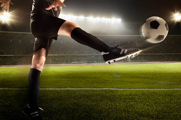 istock Athlete kicking soccer ball in stadium 637297070
