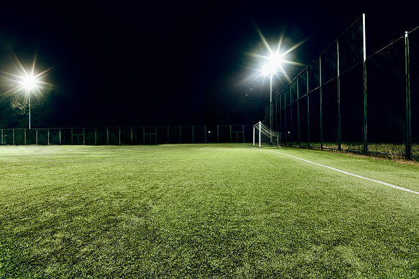 vue du terrain de football illuminé la nuit - playing surface photos et images de collection