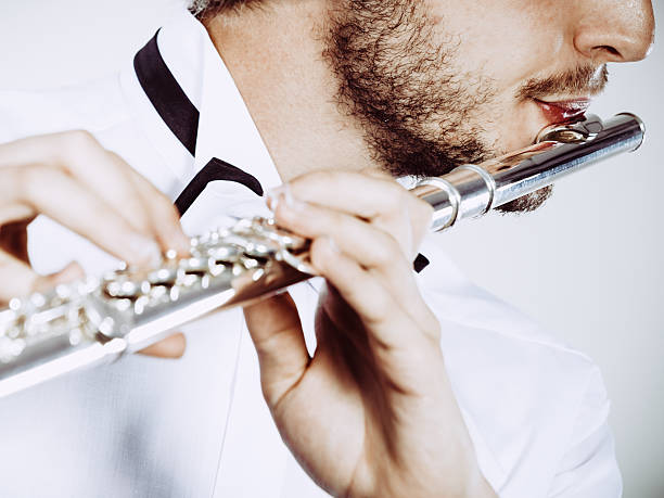 istock Male flutist playing his flute closeup 637297534