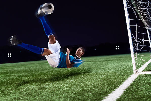 istock Athlete kicking soccer ball into a goal 637298136