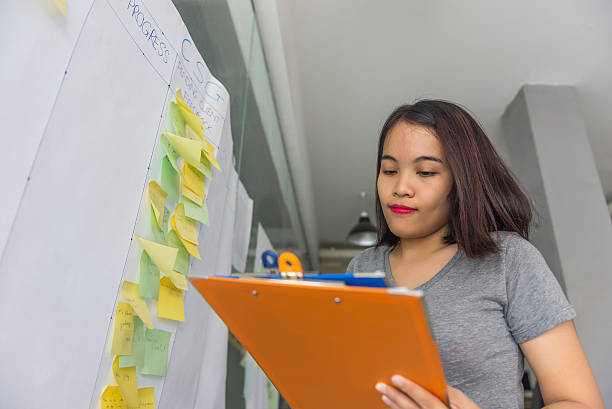 istock Woman reading document in office with many sticky notes behind 637300444