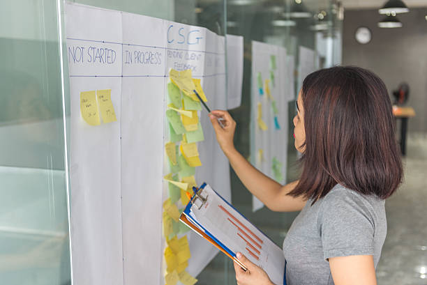 istock Woman cross-checking information in document with sticky notes 637300760