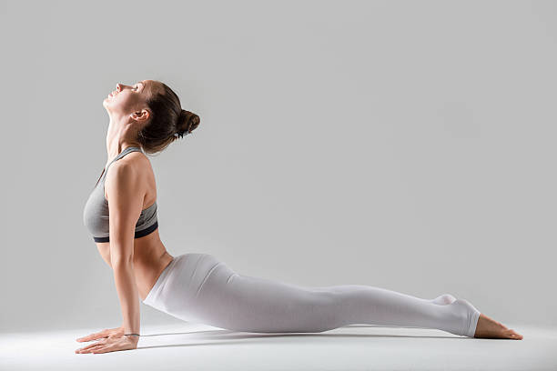 istock Young woman in Urdhva mukha shvanasana pose, grey studio backgro 637306778