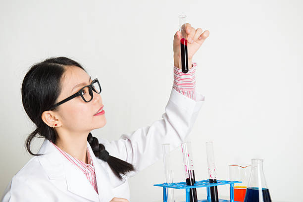 scienziata asiatica che fa esperimenti - biotechnology student laboratory nurse foto e immagini stock