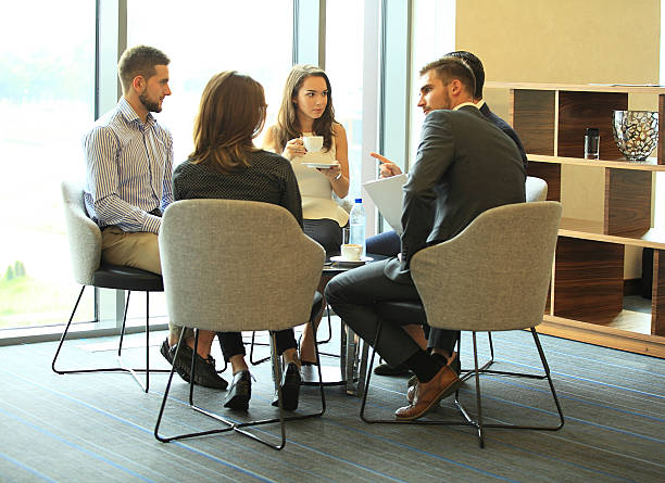 istock Group of people discussing something while sitting in office together 637309530