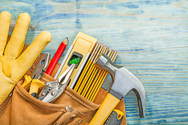 istock Leather tool belt with construction tooling on wooden board main 637311412