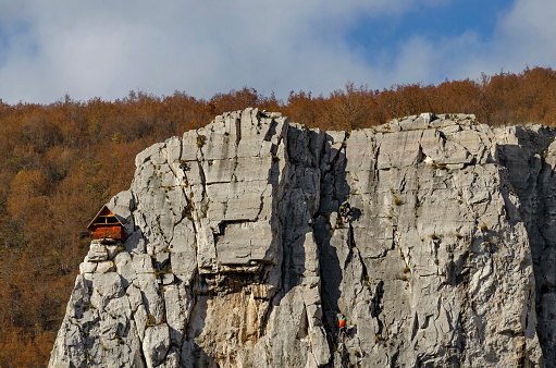 Red wooden climber house in the Lakatnik rocks and Alpine climber, Iskar river defile, Sofia province, Bulgaria