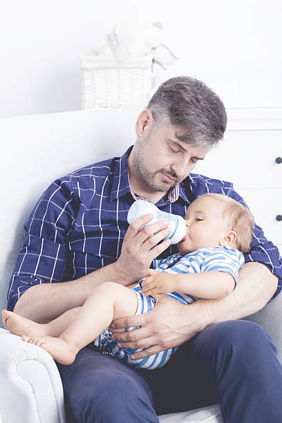 istock Father feeding baby with bottle 637316090