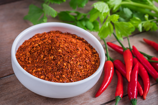 Red hot chili pepper with bowl on old wooden background.