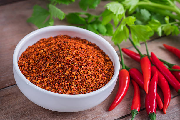 Chili cayenne in bowl and fresh chili on wooden table Chili cayenne in bowl and fresh chili on wooden table cayenne powder photos stock pictures, royalty-free photos & images