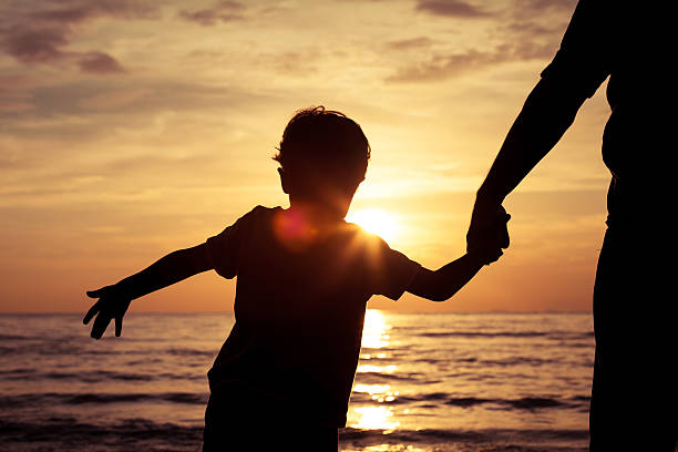 istock Father and son playing on the beach at the sunset 637316534