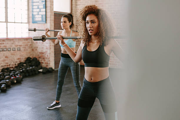 istock Females workout in gym with barbell 637320858