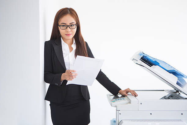 istock Content Asian Female Assistant Standing at Copier 637321838