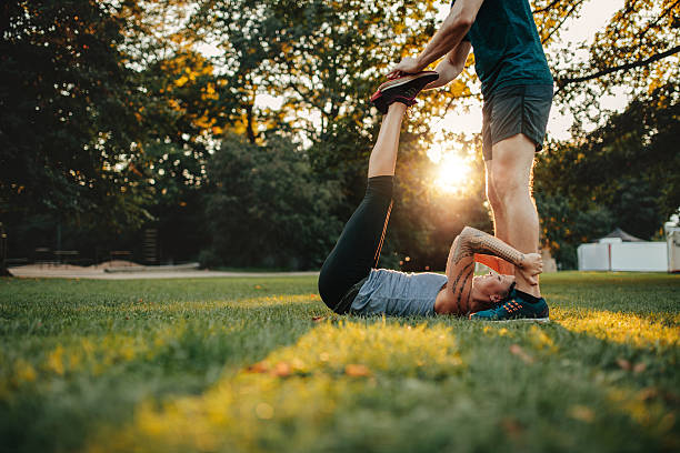 istock Personal trainer assisting woman in leg stretching workout 637325236