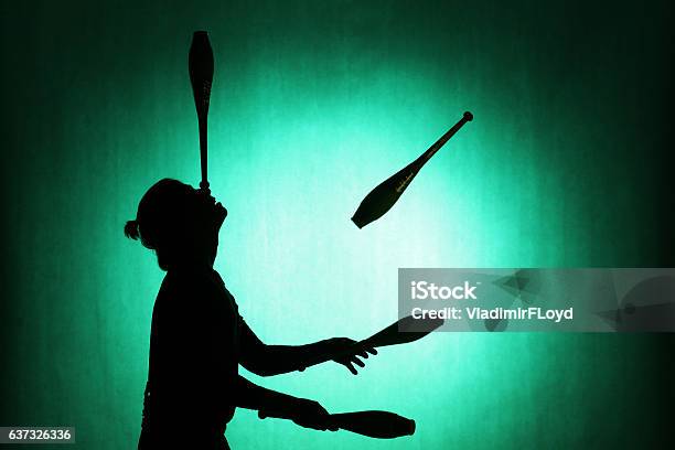 Silhouette Of A Juggler With Sticks On A Blue Background Stock Photo - Download Image Now