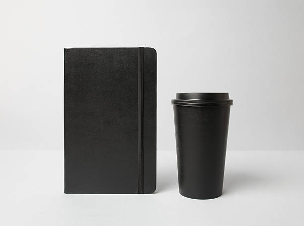 Black paper cup and moleskine stock photo