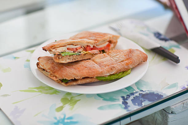 Big sandwich with meat and greens on a white plate stock photo