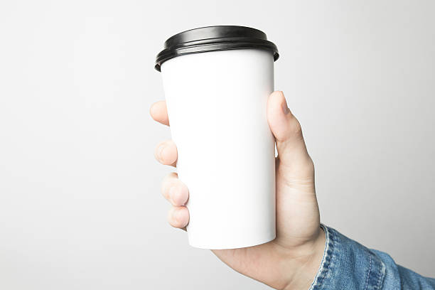 istock Hand in blue shirt is holding a white paper cup 637329606