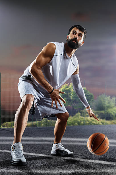 istock Basketball player is working out on night court 637330012