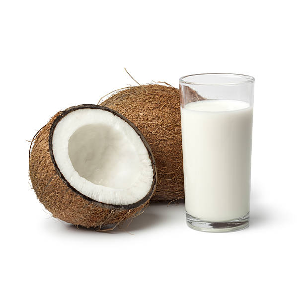 Coconut with s glass of coconut milk Coconut with a glass of coconut milk  on white background saturated fat stock pictures, royalty-free photos & images