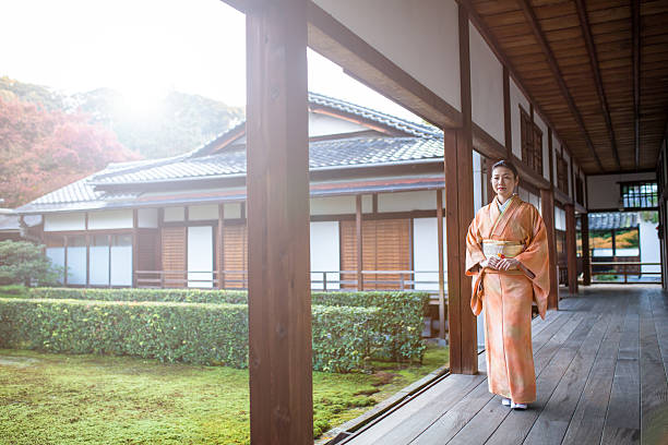 istock Woman in a kimono walking through a temple corridor 637331952