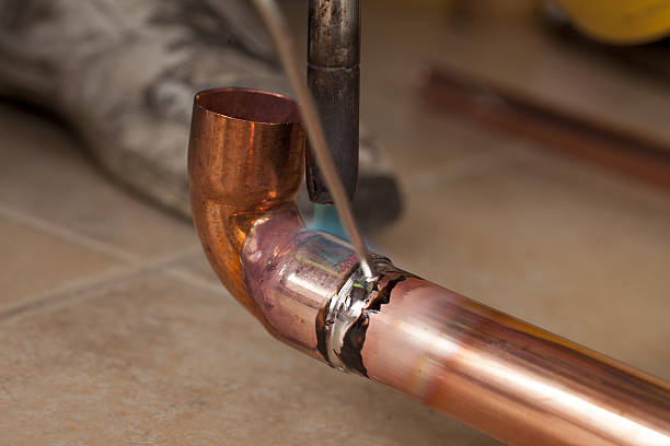 istock soldering copper pipes with tin and torch 637332164
