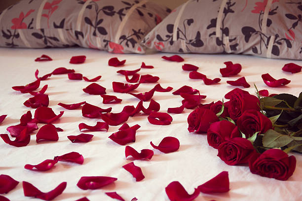 istock bouquet red roses and his scattered petals on a bed 637335902