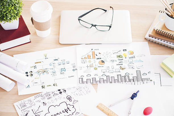 istock Wooden table with business sketches 637336954