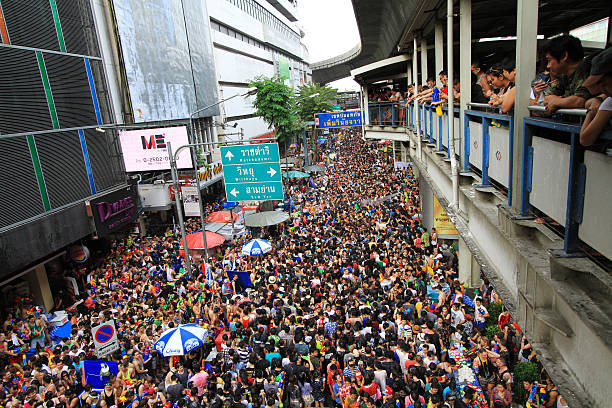 People celebrating the Songkran New Year Festival in Bangkok, Thailand. BANGKOK - APRIL 13: Crowd of people celebrating the traditional Songkran New Year Festival, April 13, 2014, Silom road, Bangkok, Thailand. silom stock pictures, royalty-free photos & images