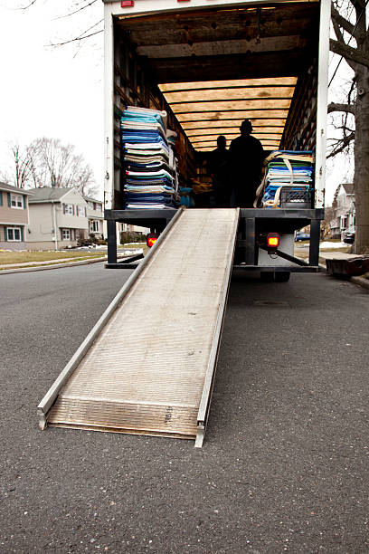 istock Moving Van with extended ramp, silhouette of men inside 637346354