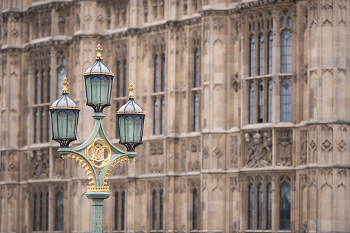 Old street lamps on the Westminster Bridge crossing the River Thames in London, England, United Kingdom. In the background is the Houses of Parliament on the north bank of the River Thames in the City of Westminster. Shallow depth of field with focus placed over the lamps. The building in the background is blurred (and may be used for copy). Westminster Bridge is a road and foot traffic, linking Westminster and Lambeth (on the south side of the river). The current Westminster Bridge opened in 1862.