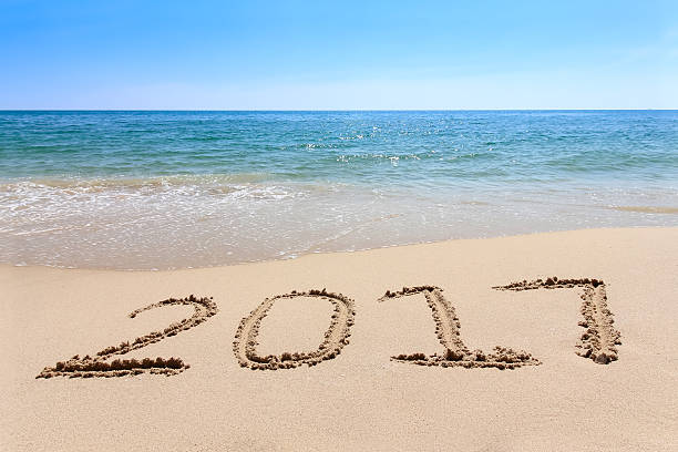 istock Year 2017 written at the sand beach with sea wave 637348402