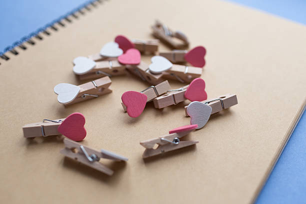 istock Clothespins with hearts are Notepad. Background blue paper 637349324
