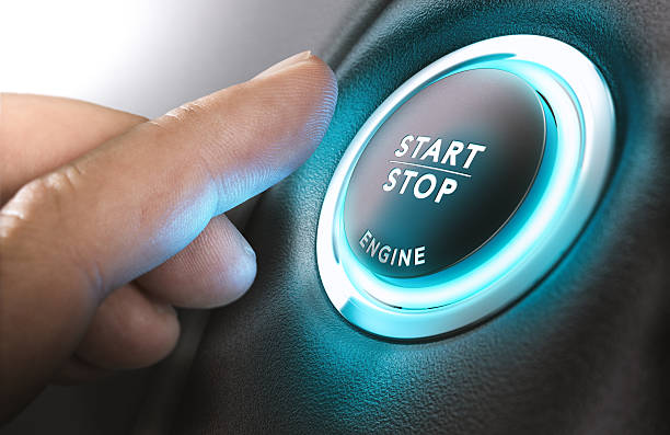 Car Start and Stop Button Car stop start system with finger pressing the button, horizontal image ignition photos stock pictures, royalty-free photos & images