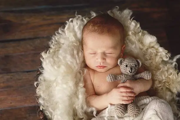 Photo of NewbornBaby Boy Sleeping with Teddy Bear