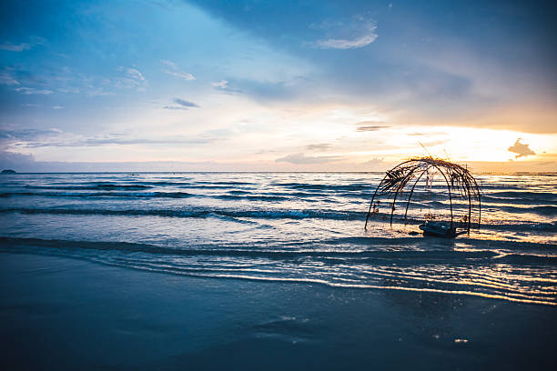piège à poissons à l’océan au coucher du soleil en thaïlande - fischernetz photos et images de collection