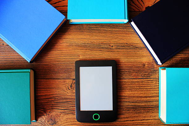 istock E-book reader and books on wooden background 637358666