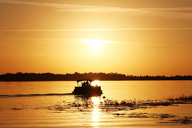 istock People on a boat watching the sunset at the lake 637359814