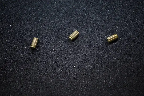 Cases of bullets lying on the floor of asphalt