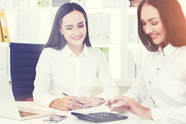 istock Two women in white shirts working in the office 637364060