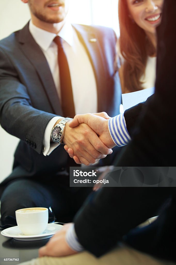 Pessoas de negócios apertando as mãos, terminando uma reunião. - Foto de stock de Dar as Mãos royalty-free